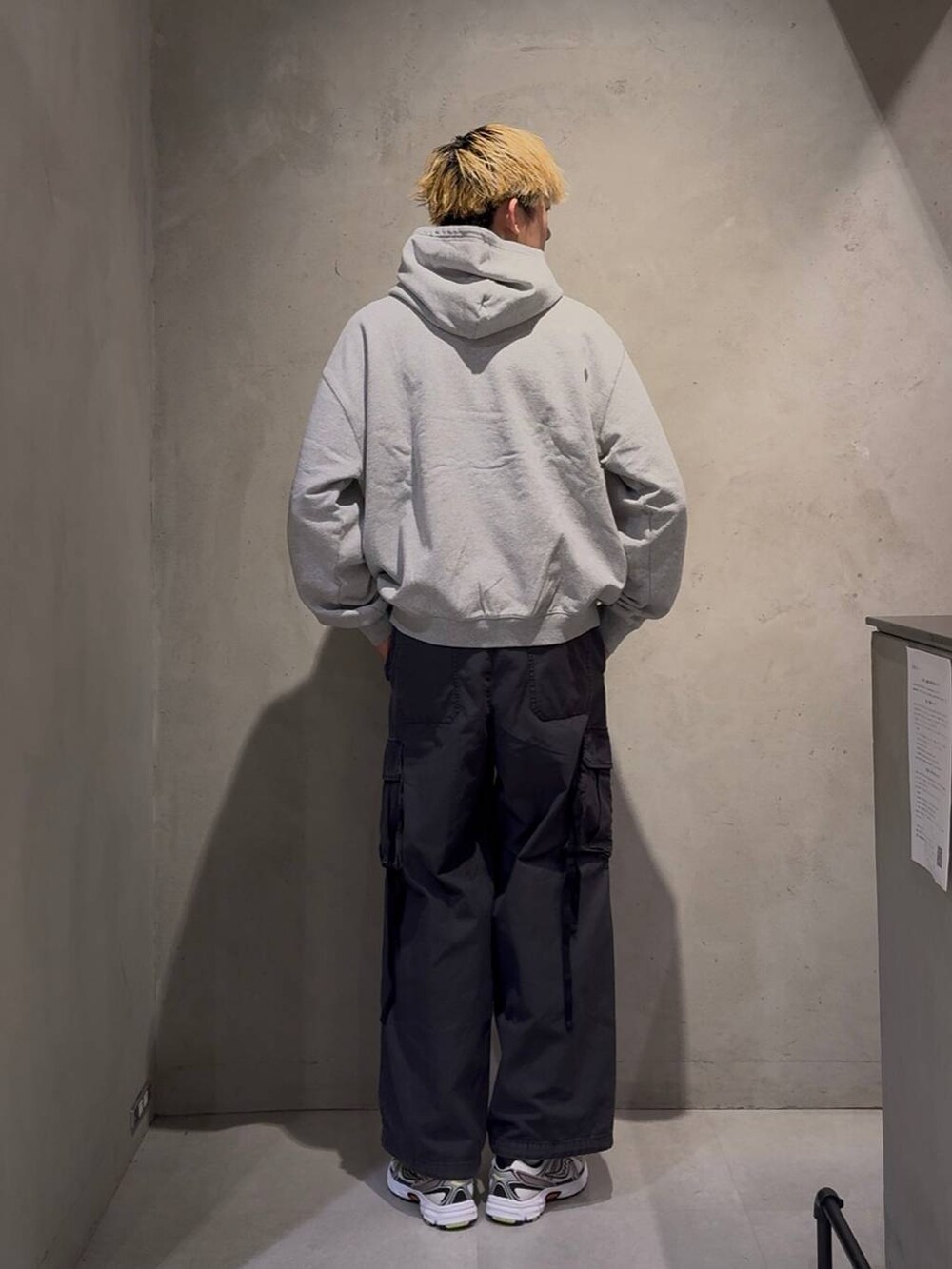 ブラック系のカーゴパンツ、グレー系のパーカー、ホワイト系のネックレスを着用したメンズの冬コーディネートの4枚目の写真