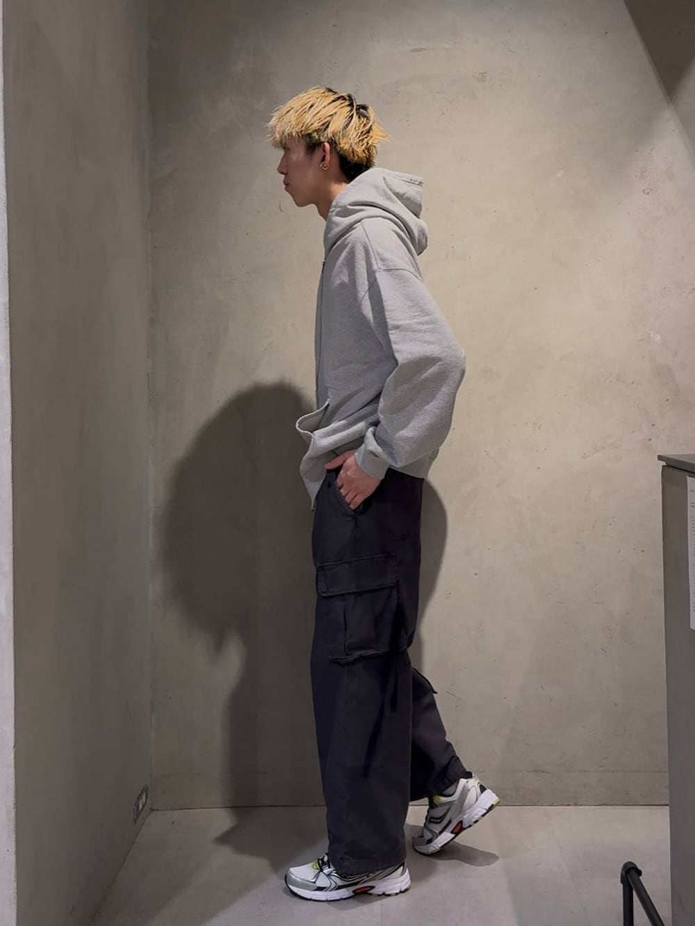 ブラック系のカーゴパンツ、グレー系のパーカー、ホワイト系のネックレスを着用したメンズの冬コーディネートの3枚目の写真