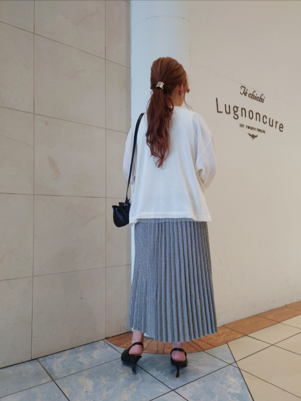 ブラック系のパンプス、ホワイト系のニット/セーター、ブラック系のハンドバッグを着用したレディースの春コーディネートの5枚目の写真