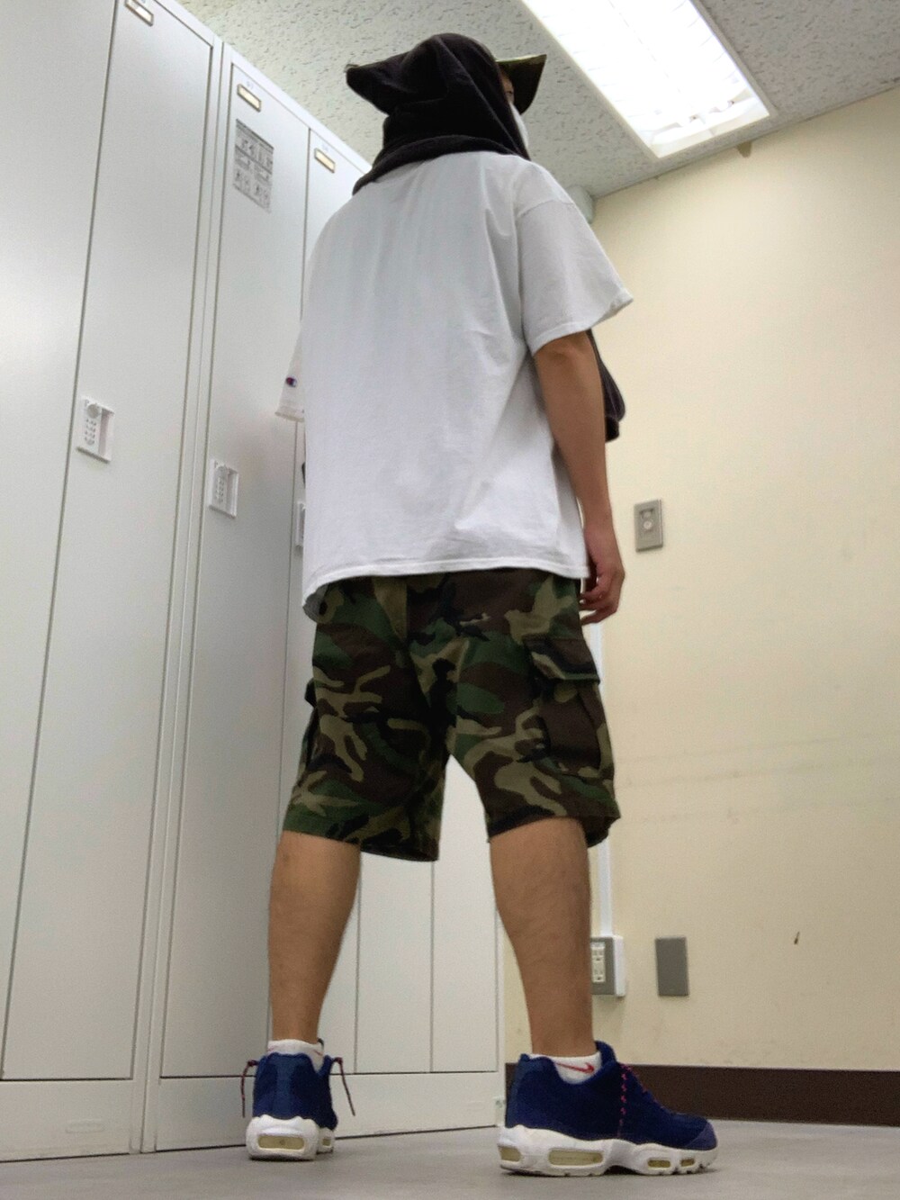 ホワイト系のTシャツ/カットソー、グリーン系のカーゴパンツ、ブルー系のスニーカーを着用したメンズの夏コーディネートの2枚目の写真