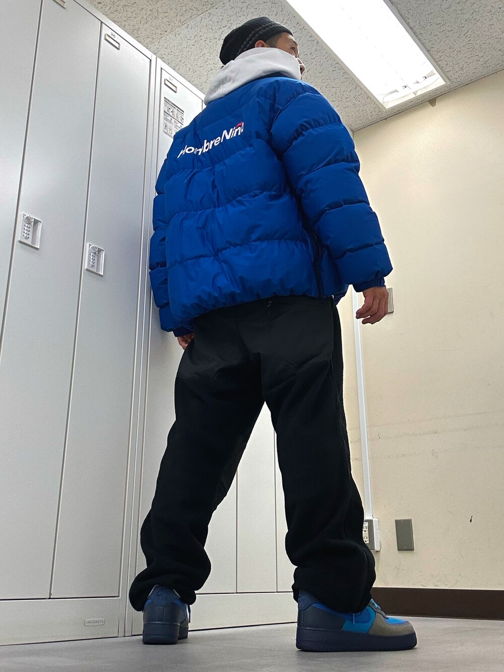 ホワイト系のパーカー、ブルー系のダウンジャケット/コート、ブラック系のその他パンツを着用したメンズの冬コーディネートの3枚目の写真