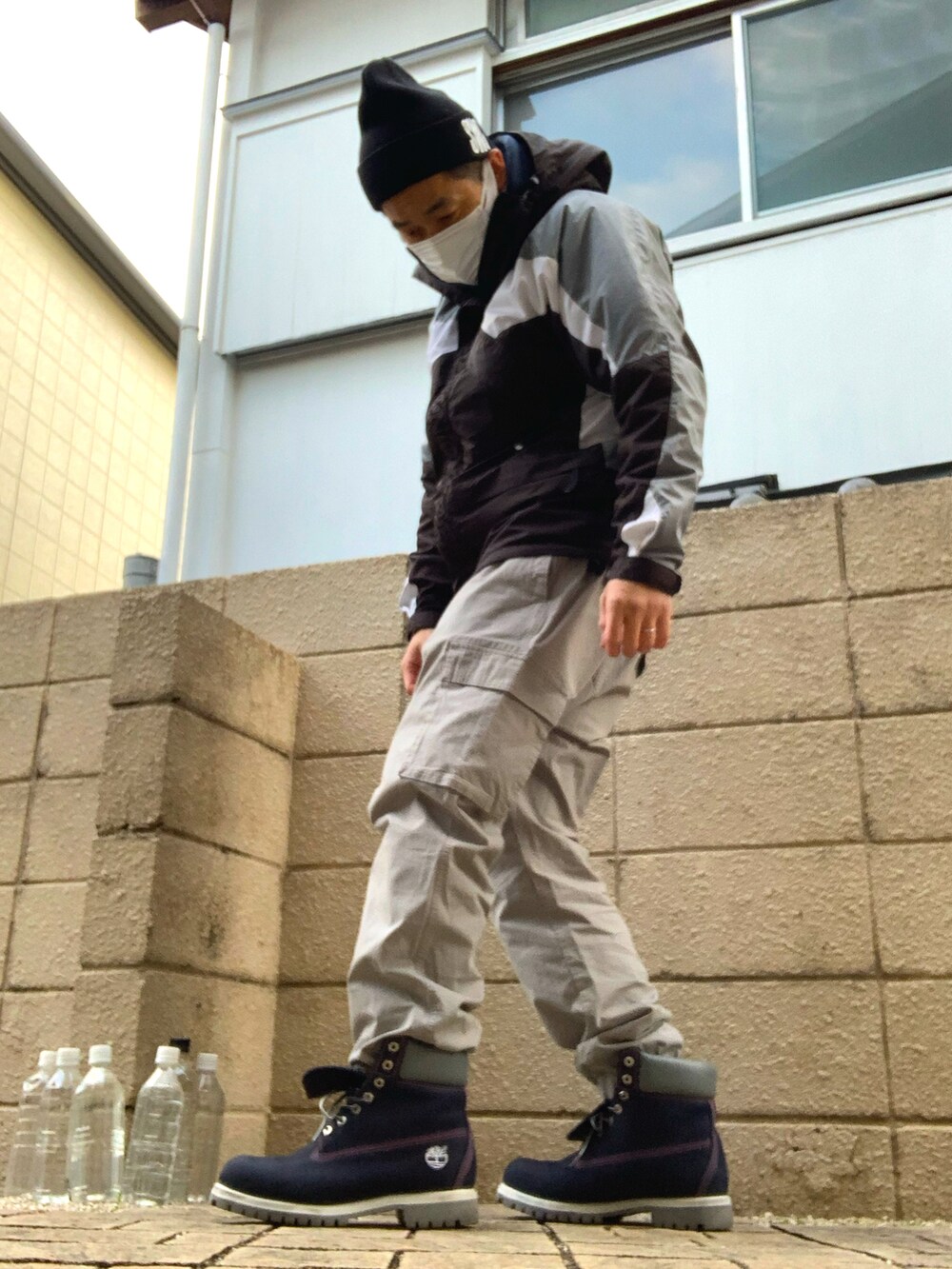 グレー系のマウンテンパーカー、グレー系のカーゴパンツ、ブルー系のブーツを着用したメンズの冬コーディネートの2枚目の写真