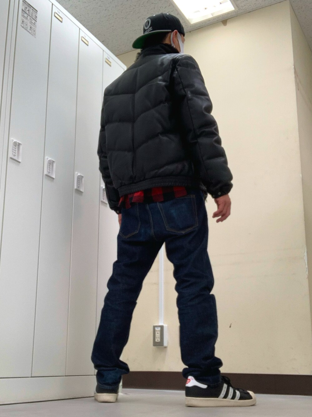 レッド系のシャツ/ブラウス、ブラック系のダウンジャケット/コート、ブルー系のデニムパンツを着用したメンズの冬コーディネートの2枚目の写真