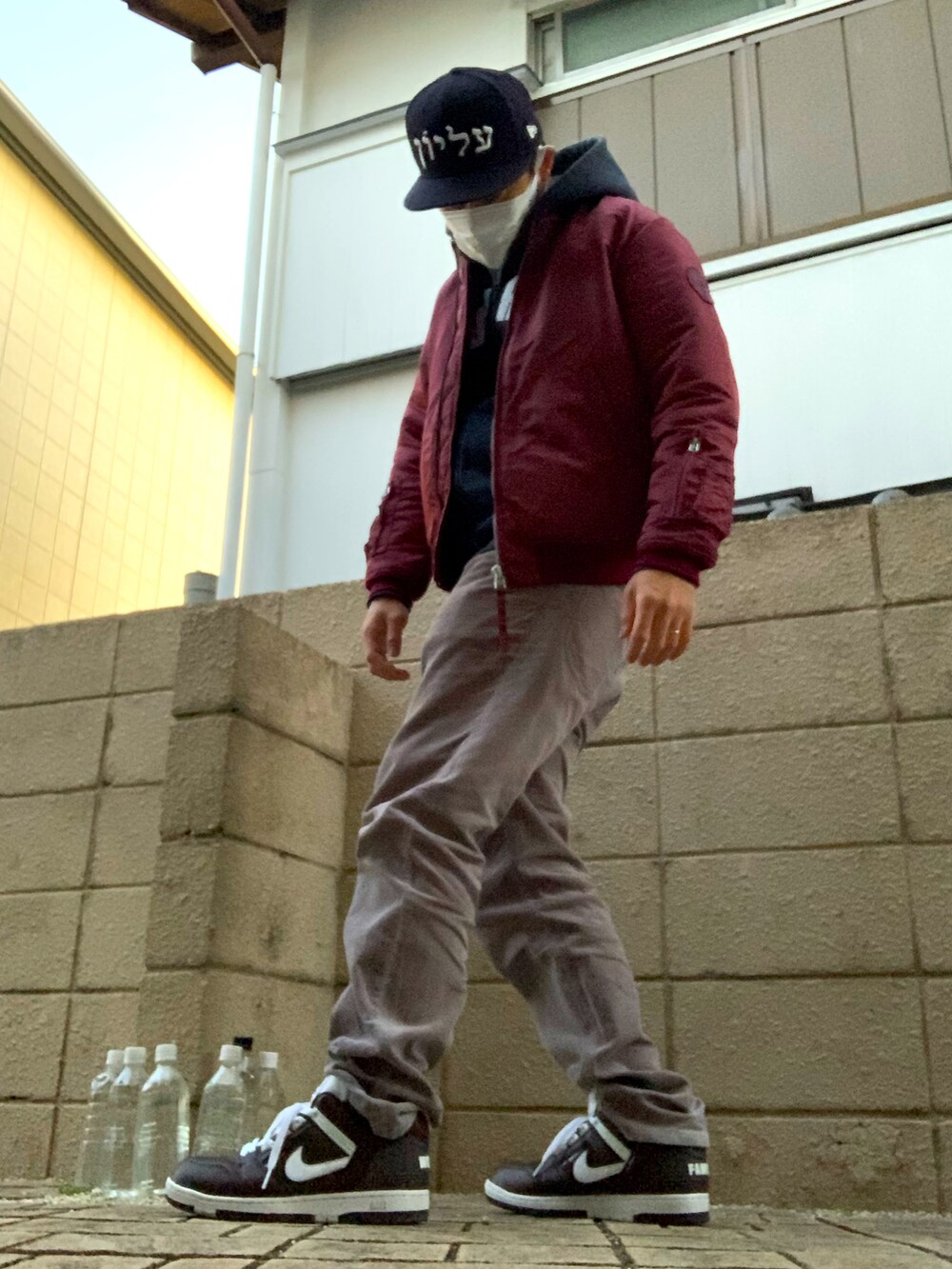 レッド系のミリタリージャケット、グレー系のその他パンツ、ブラウン系のスニーカーを着用したメンズの冬コーディネートの2枚目の写真