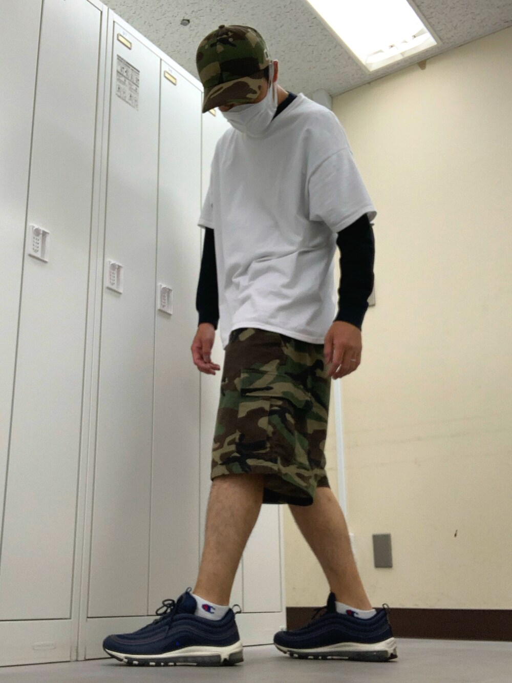 ホワイト系のTシャツ/カットソー、グリーン系のカーゴパンツ、ブルー系のスニーカーを着用したメンズの夏コーディネートの3枚目の写真