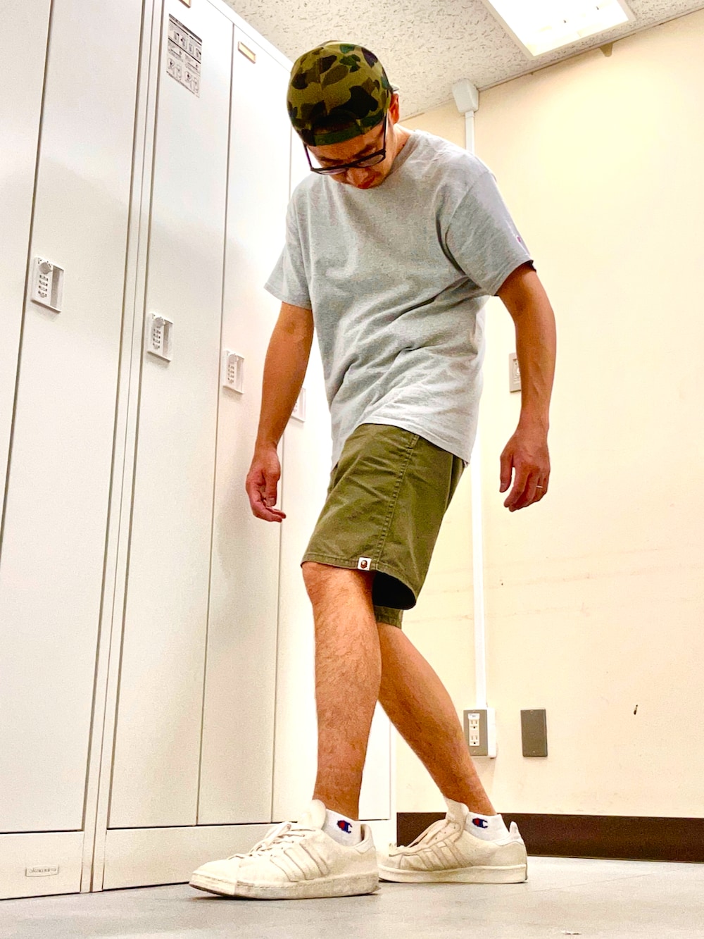 グレー系のTシャツ/カットソー、グリーン系のチノパンツ、ベージュ系のスニーカーを着用したメンズの夏コーディネートの2枚目の写真