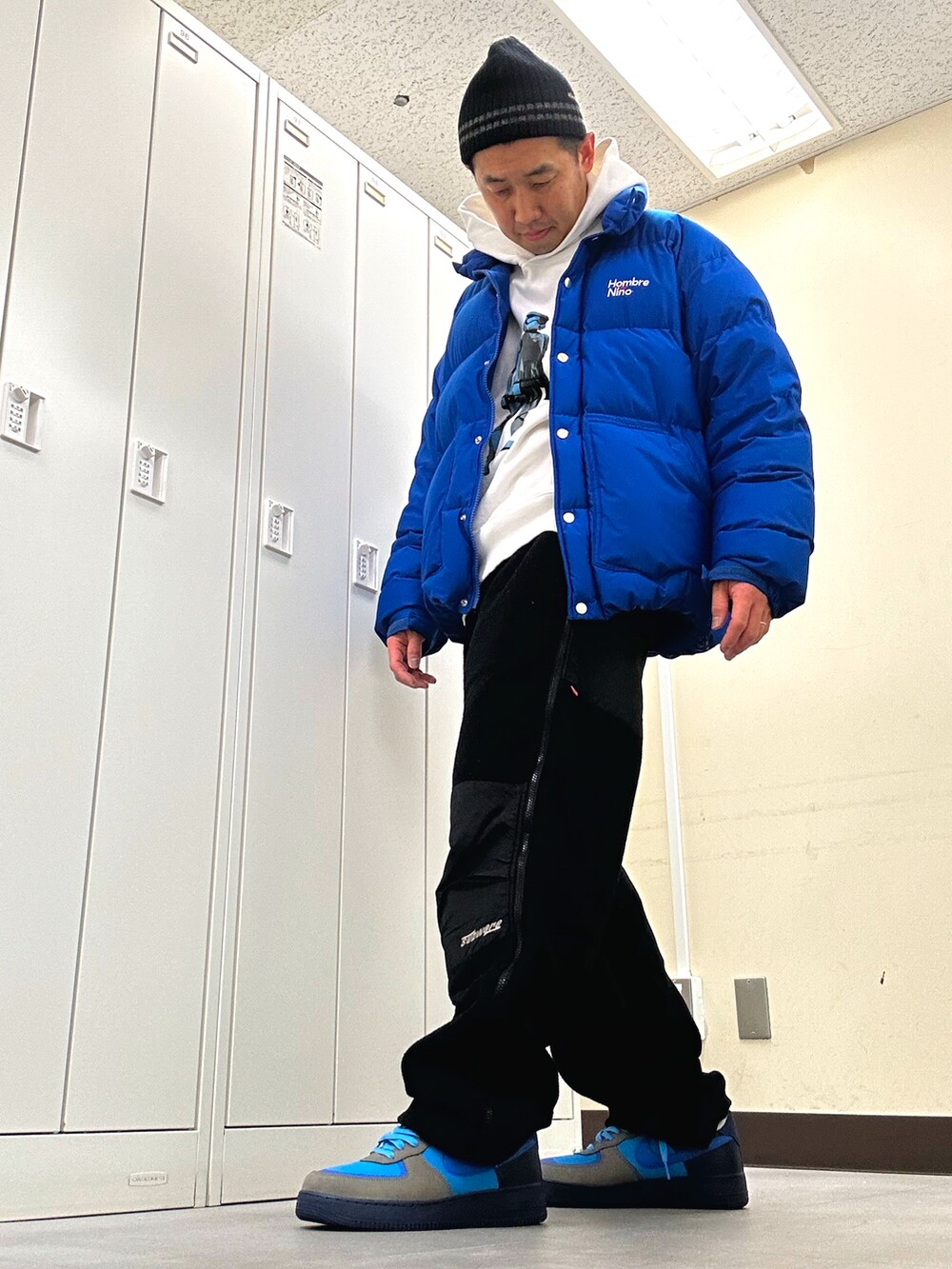 ホワイト系のパーカー、ブルー系のダウンジャケット/コート、ブラック系のその他パンツを着用したメンズの冬コーディネートの2枚目の写真