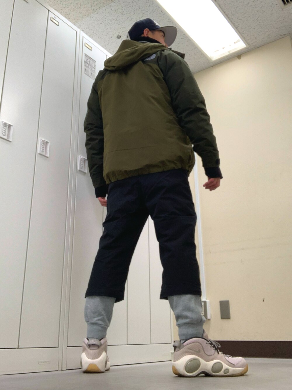 グリーン系のマウンテンパーカー、ブルー系のTシャツ/カットソー、ブラック系のその他パンツを着用したメンズの冬コーディネートの3枚目の写真