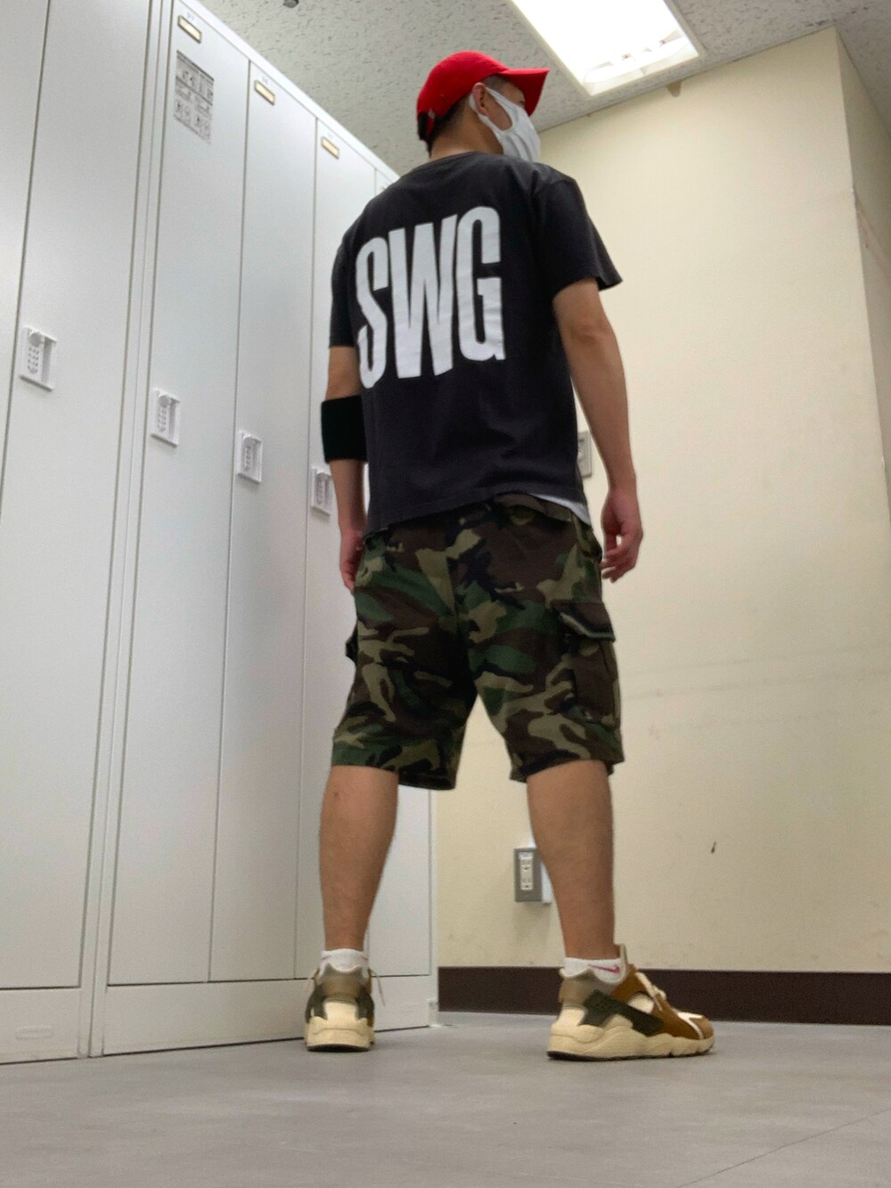 ブラック系のTシャツ/カットソー、グリーン系のカーゴパンツ、ブラウン系のスニーカーを着用したメンズの夏コーディネートの2枚目の写真