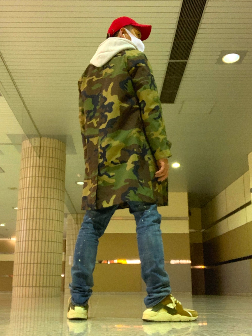 グリーン系のナイロンジャケット、ブルー系のデニムパンツ、ベージュ系のスニーカーを着用したメンズの春コーディネートの2枚目の写真