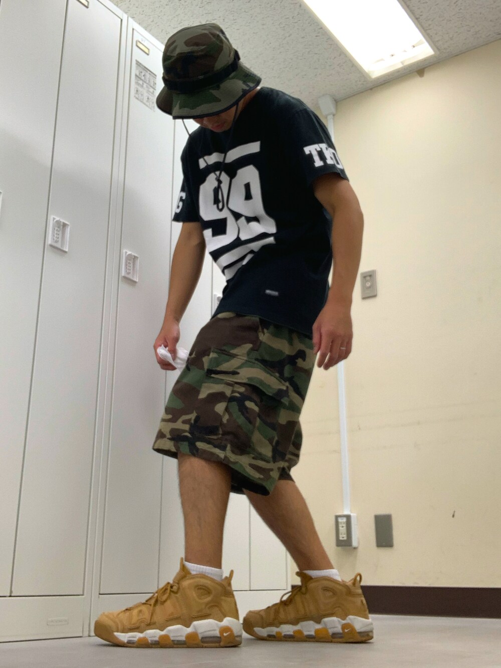 ブラック系のTシャツ/カットソー、グリーン系のカーゴパンツ、ベージュ系のスニーカーを着用したメンズの秋コーディネートの2枚目の写真