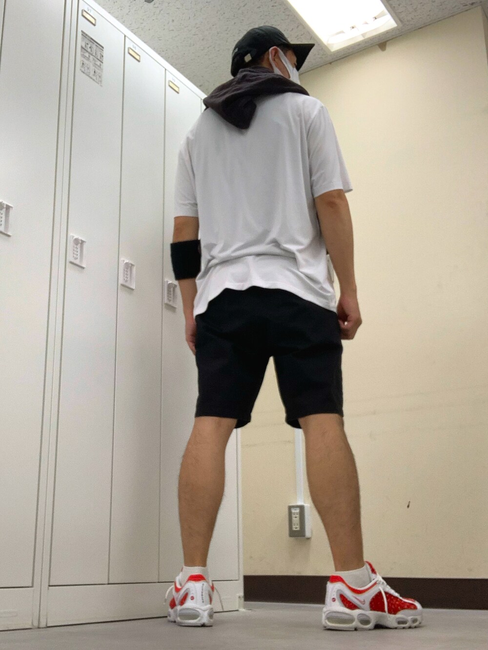 ホワイト系のTシャツ/カットソー、ブラック系のチノパンツ、レッド系のスニーカーを着用したメンズの夏コーディネートの2枚目の写真