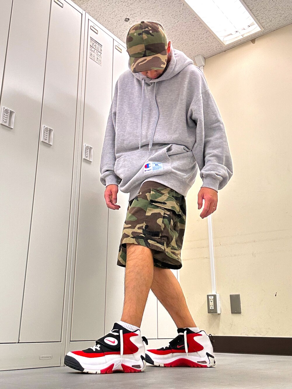 グレー系のパーカー、グリーン系のカーゴパンツ、レッド系のスニーカーを着用したメンズの秋コーディネートの2枚目の写真