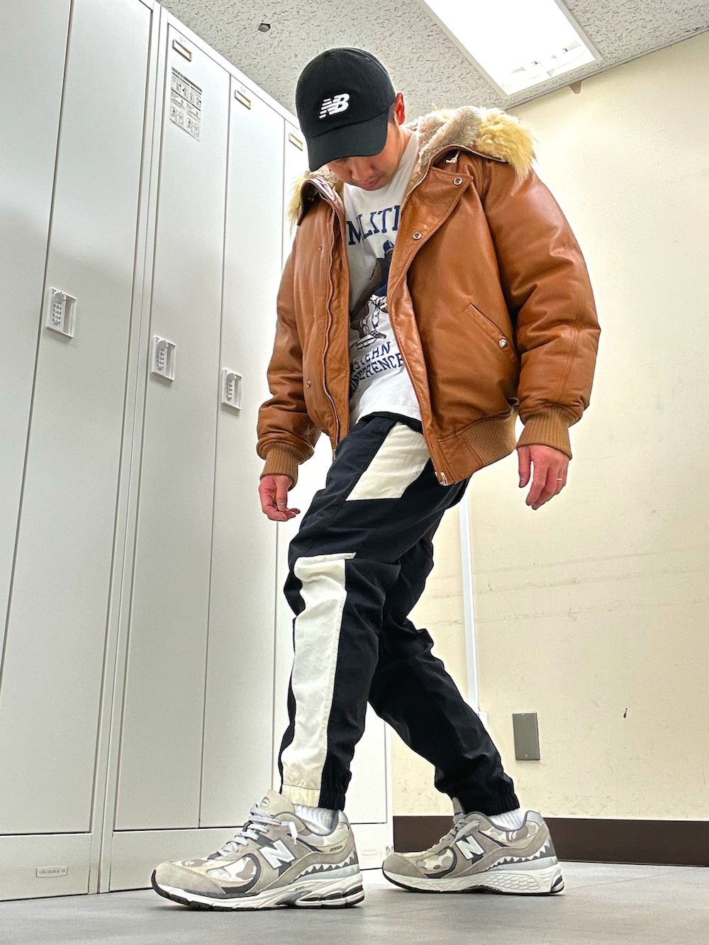 ブラウン系のミリタリージャケット、ブラック系のその他パンツ、グレー系のスニーカーを着用したメンズの冬コーディネートの2枚目の写真