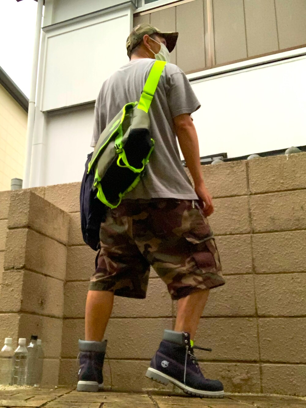 グレー系のTシャツ/カットソー、ブルー系のナイロンジャケット、グリーン系のカーゴパンツを着用したメンズの秋コーディネートの2枚目の写真