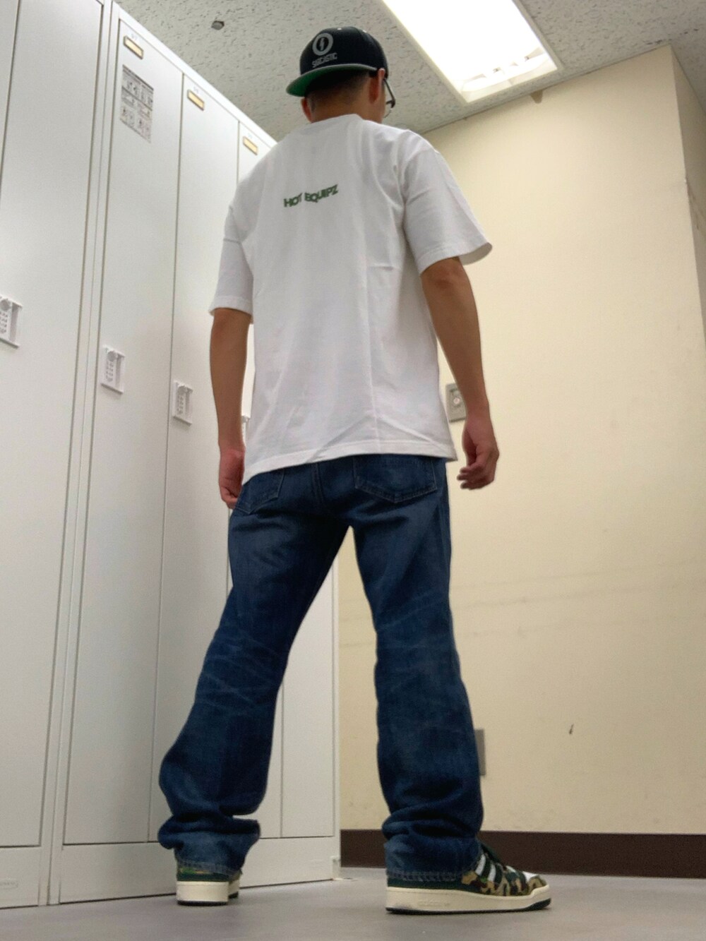 ホワイト系のTシャツ/カットソー、ブルー系のデニムパンツ、グリーン系のスニーカーを着用したメンズの秋コーディネートの3枚目の写真