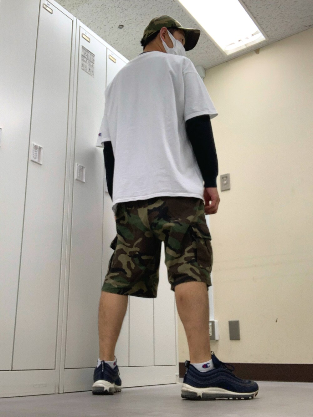 ホワイト系のTシャツ/カットソー、グリーン系のカーゴパンツ、ブルー系のスニーカーを着用したメンズの夏コーディネートの2枚目の写真