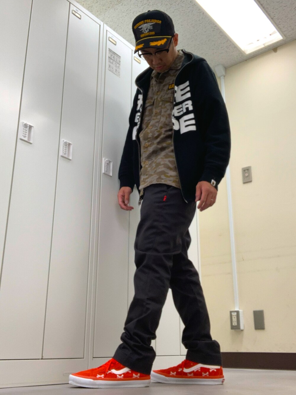 グリーン系のシャツ/ブラウス、ブラック系のパーカー、グレー系のチノパンツを着用したメンズの秋コーディネートの2枚目の写真
