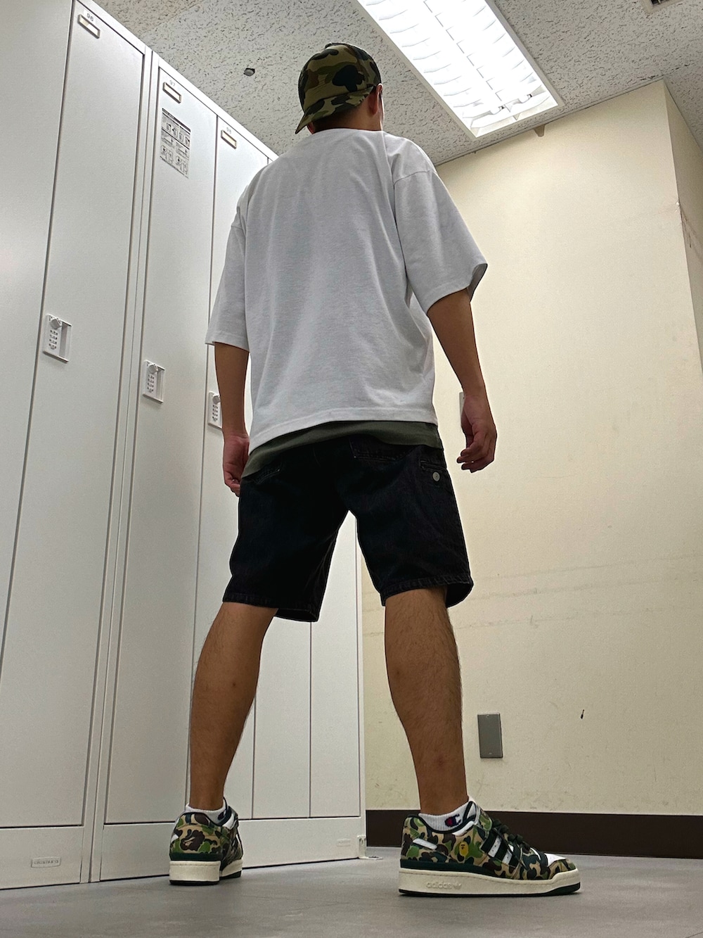 ホワイト系のTシャツ/カットソー、ブラック系のデニムパンツ、グリーン系のスニーカーを着用したメンズの秋コーディネートの3枚目の写真