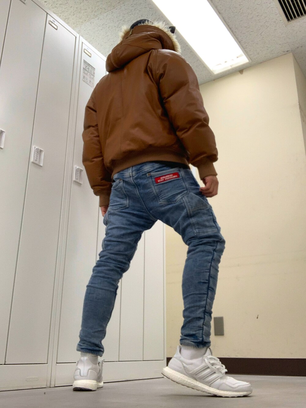 ブラウン系のジャケット/アウター、ブルー系のその他パンツ、ホワイト系のスニーカーを着用したメンズの冬コーディネートの3枚目の写真