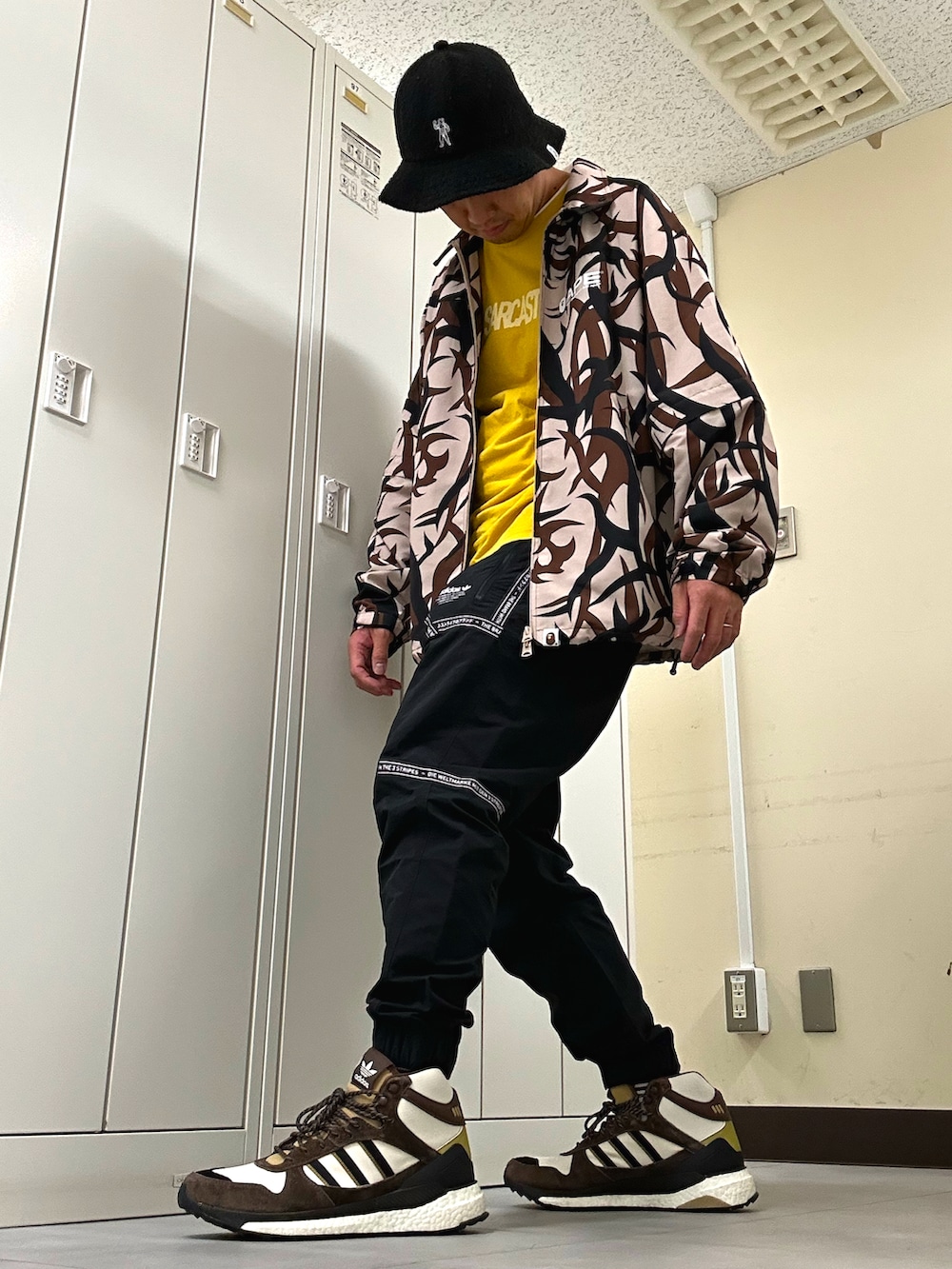 ベージュ系のナイロンジャケット、ブラック系のその他パンツ、ベージュ系のスニーカーを着用したメンズの秋コーディネートの2枚目の写真