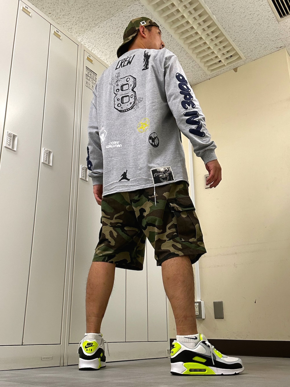 グレー系のTシャツ/カットソー、グリーン系のカーゴパンツ、ホワイト系のスニーカーを着用したメンズの春コーディネートの3枚目の写真