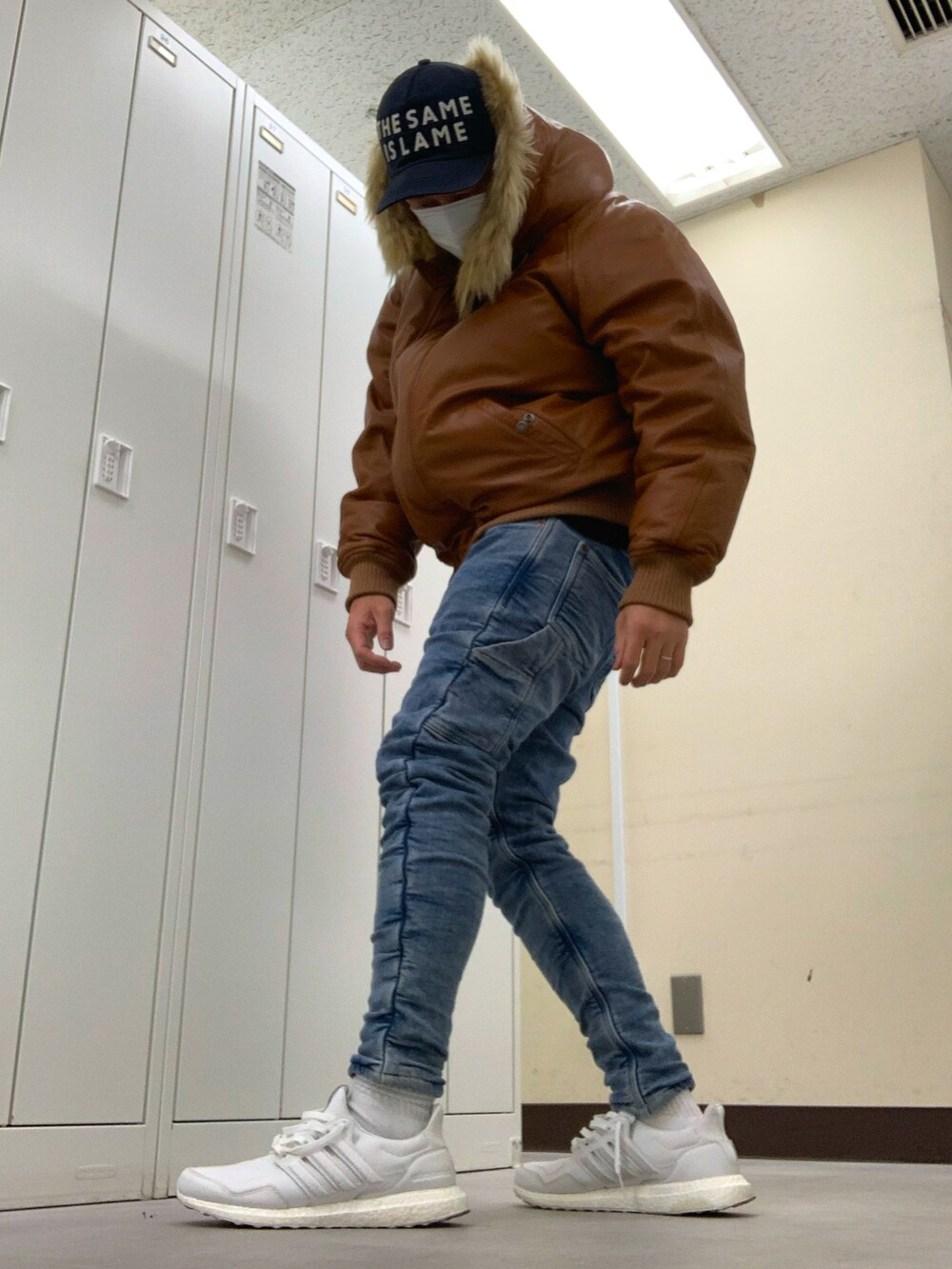 ブラウン系のジャケット/アウター、ブルー系のその他パンツ、ホワイト系のスニーカーを着用したメンズの冬コーディネートの2枚目の写真