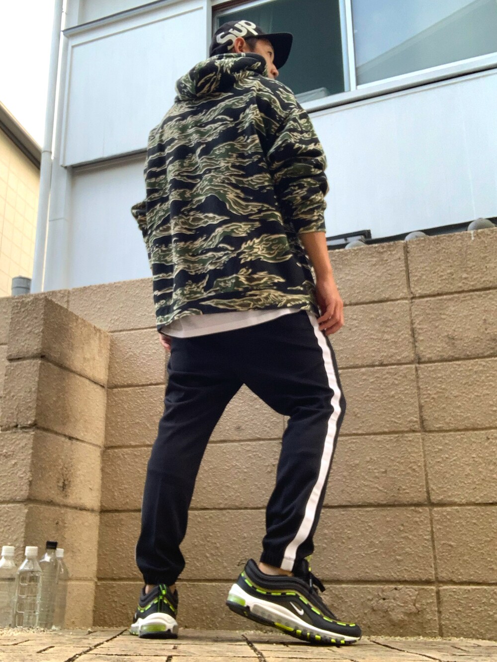 グリーン系のパーカー、ブラック系のその他パンツ、ブラック系のスニーカーを着用したメンズの秋コーディネートの2枚目の写真