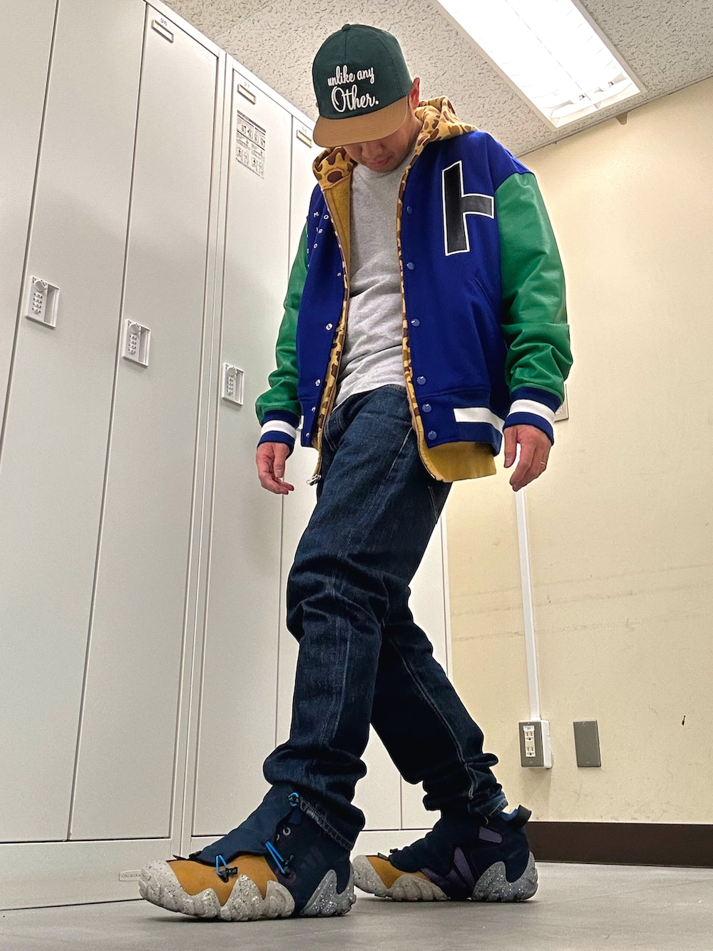 ブルー系のスタジャン、ブルー系のデニムパンツ、ブルー系のスニーカーを着用したメンズの冬コーディネートの2枚目の写真