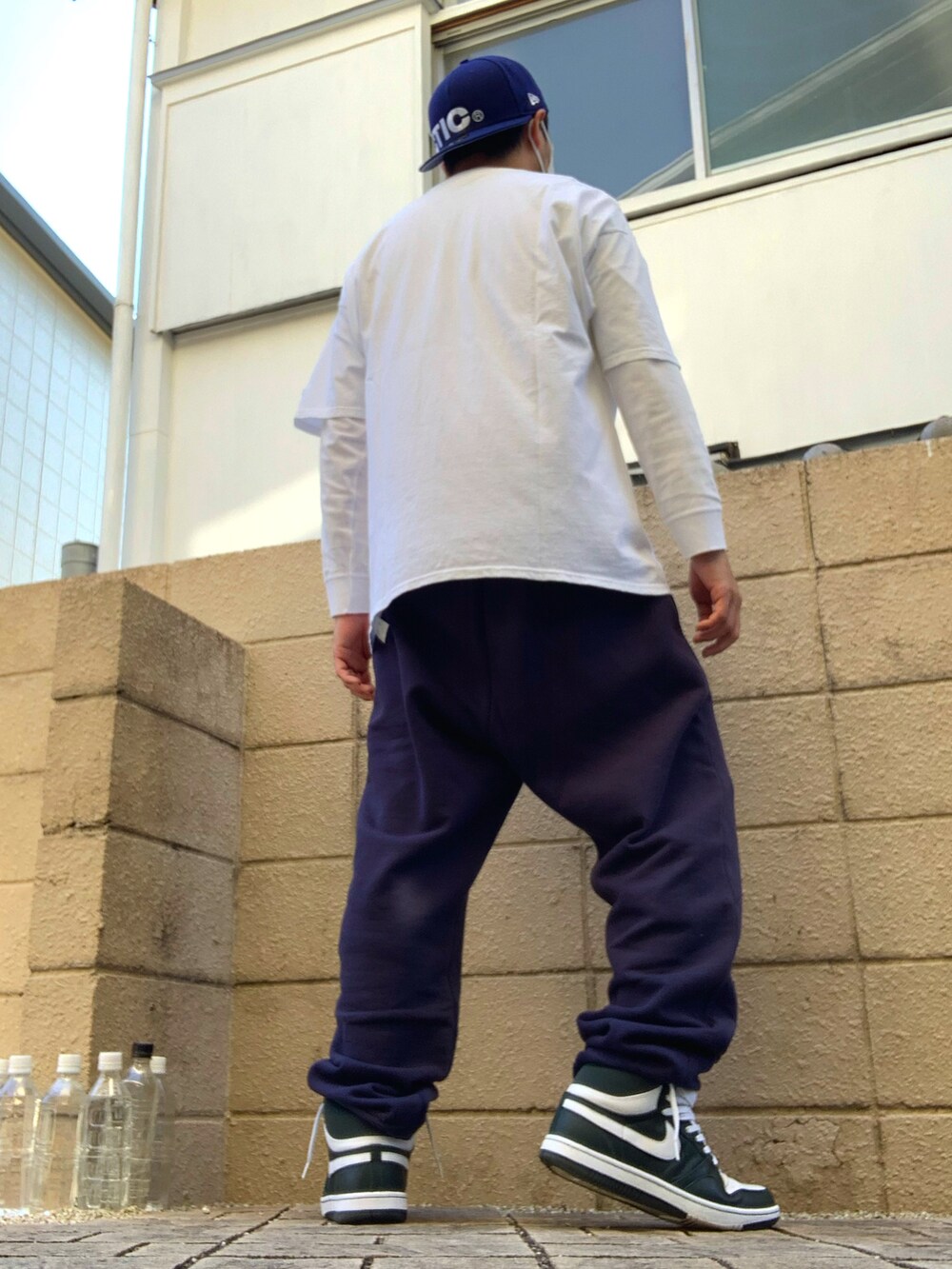 ホワイト系のTシャツ/カットソー、ブルー系のスウェットパンツ、グリーン系のスニーカーを着用したメンズの秋コーディネートの2枚目の写真