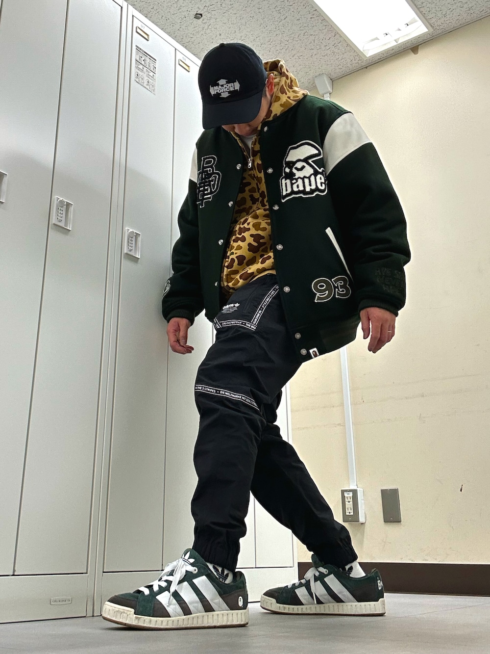 グリーン系のスタジャン、ブラック系のその他パンツ、グリーン系のスニーカーを着用したメンズの冬コーディネートの2枚目の写真