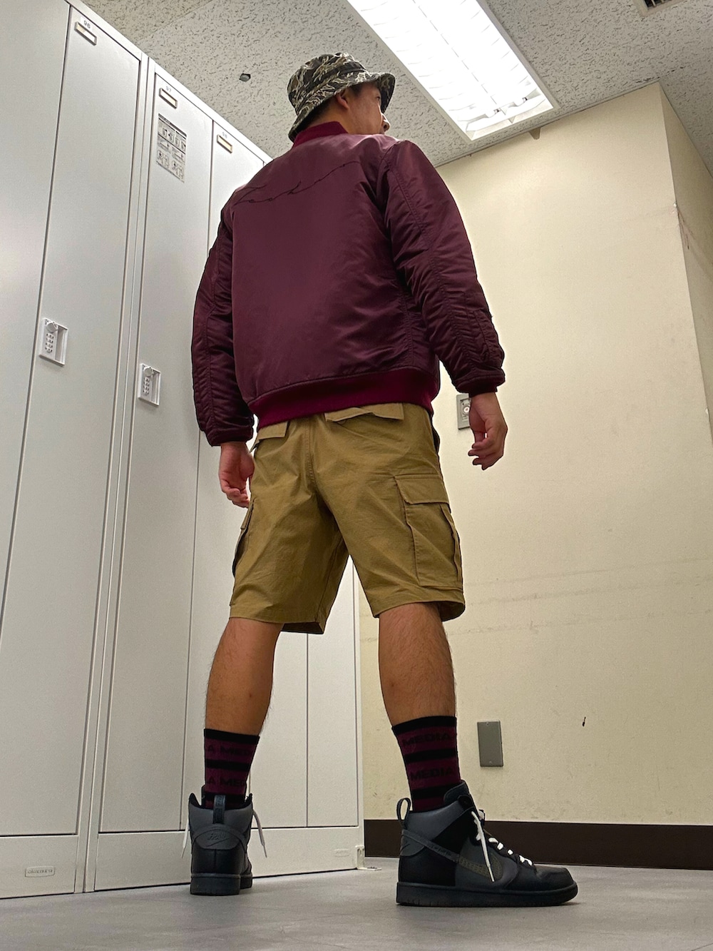 レッド系のジャケット/アウター、ベージュ系のカーゴパンツ、ブラック系のスニーカーを着用したメンズの秋コーディネートの3枚目の写真