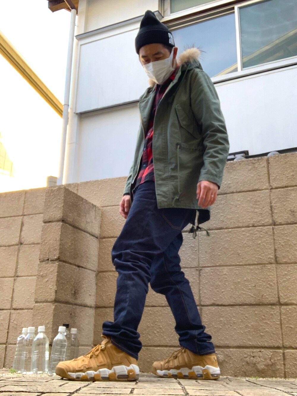 レッド系のシャツ/ブラウス、グリーン系のミリタリージャケット、ブルー系のデニムパンツを着用したメンズの冬コーディネートの2枚目の写真