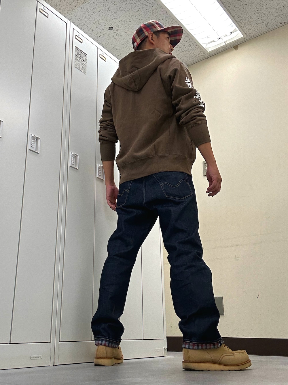 ホワイト系のTシャツ/カットソー、ブラウン系のパーカー、ブルー系のデニムパンツを着用したメンズの秋コーディネートの3枚目の写真