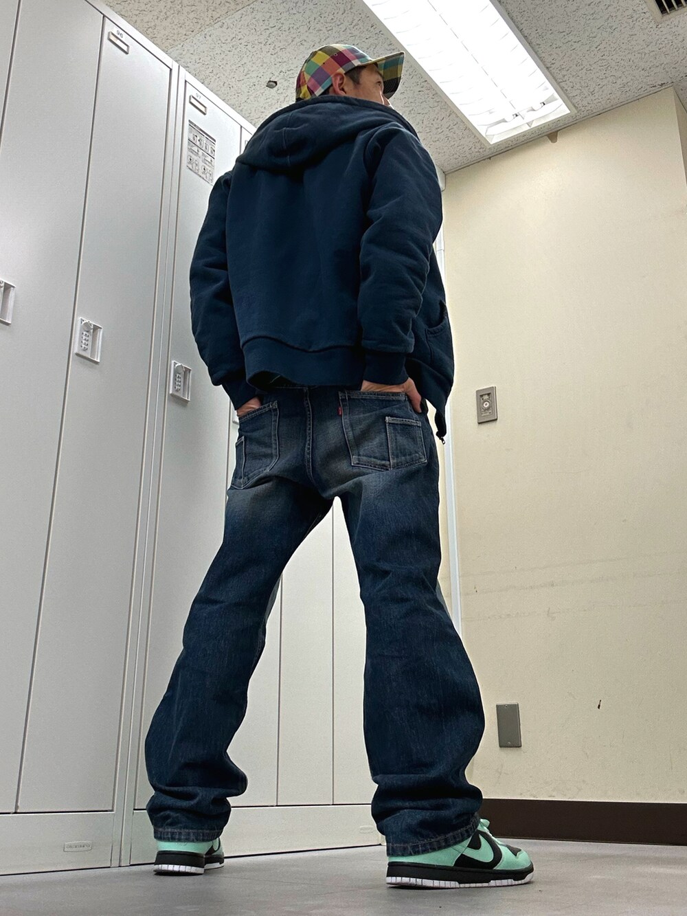 グリーン系のTシャツ/カットソー、ブルー系のパーカー、ブルー系のデニムパンツを着用したメンズの春コーディネートの3枚目の写真