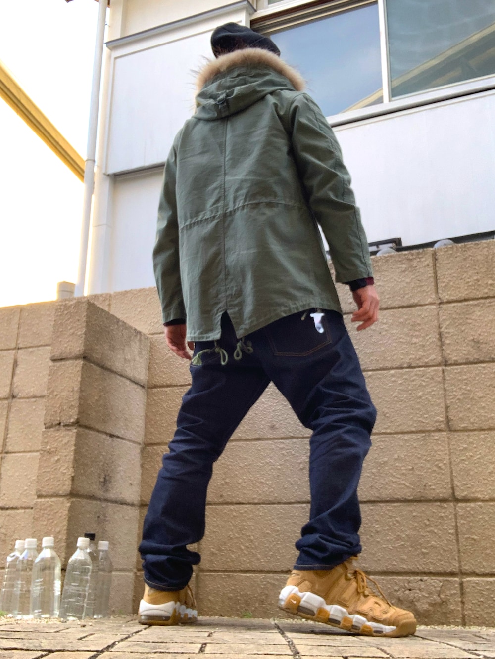 レッド系のシャツ/ブラウス、グリーン系のミリタリージャケット、ブルー系のデニムパンツを着用したメンズの冬コーディネートの3枚目の写真