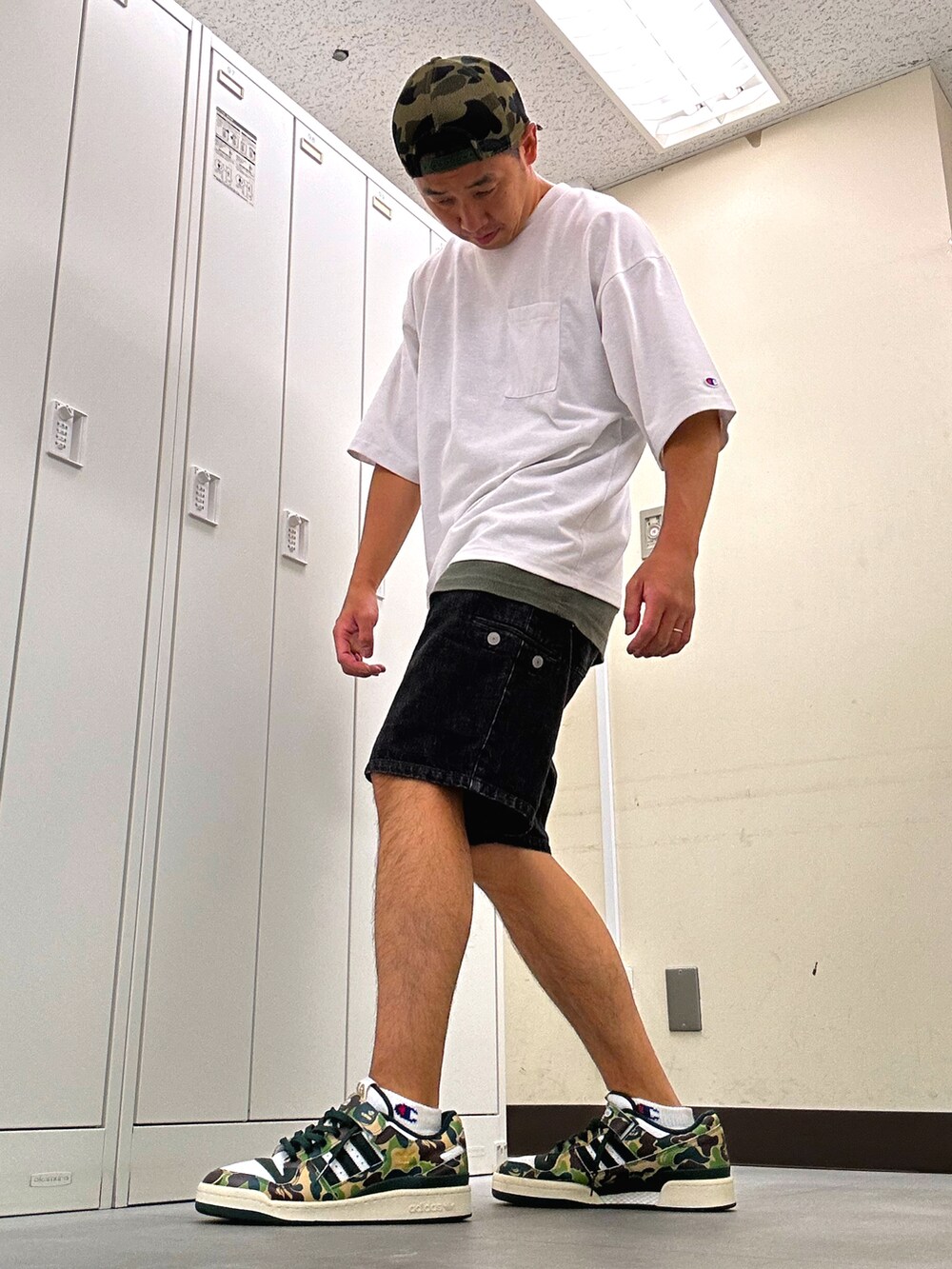 ホワイト系のTシャツ/カットソー、ブラック系のデニムパンツ、グリーン系のスニーカーを着用したメンズの秋コーディネートの2枚目の写真