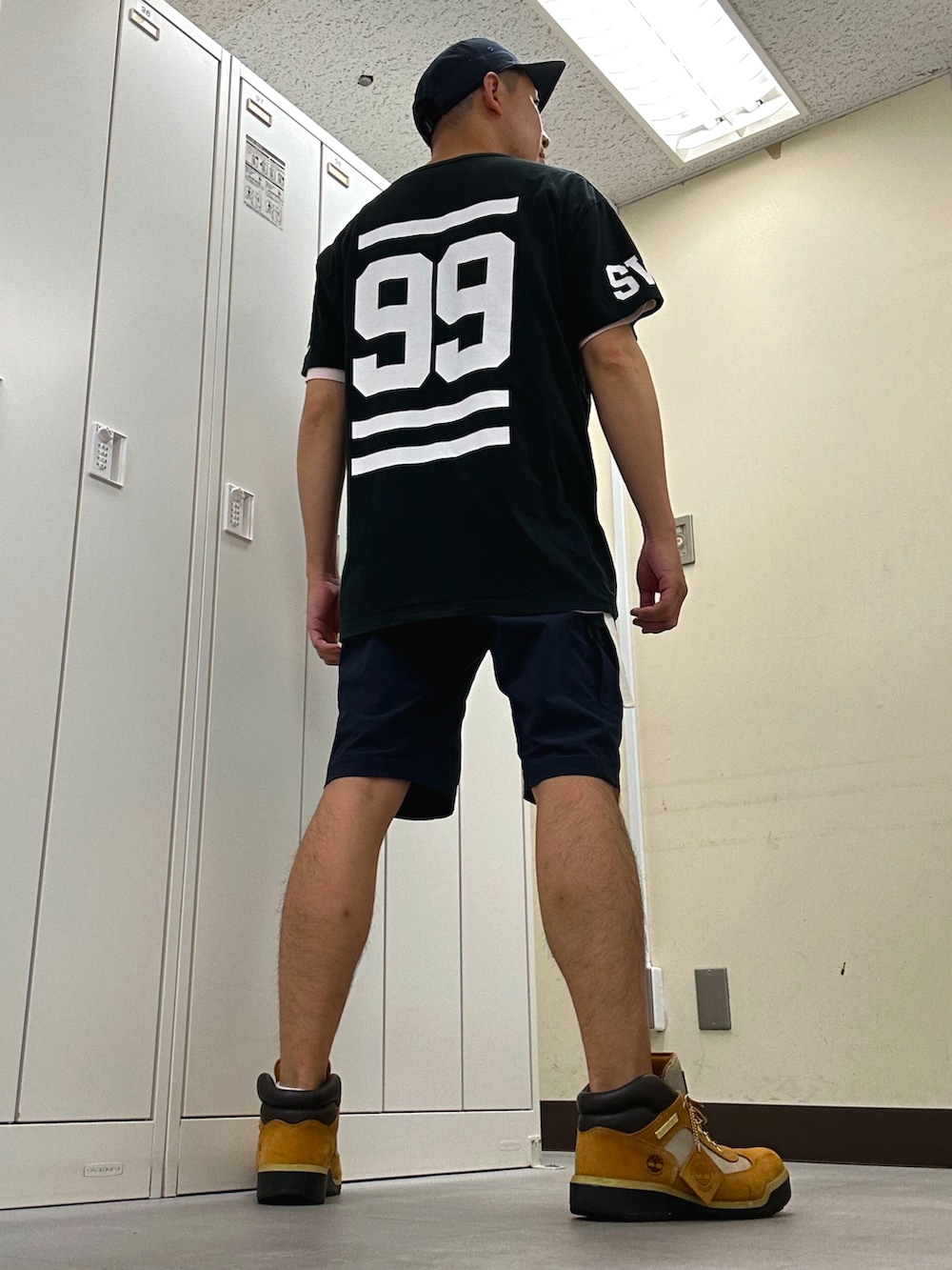 ブラック系のTシャツ/カットソー、ブルー系のパンツ、ベージュ系のブーツを着用したメンズの夏コーディネートの3枚目の写真