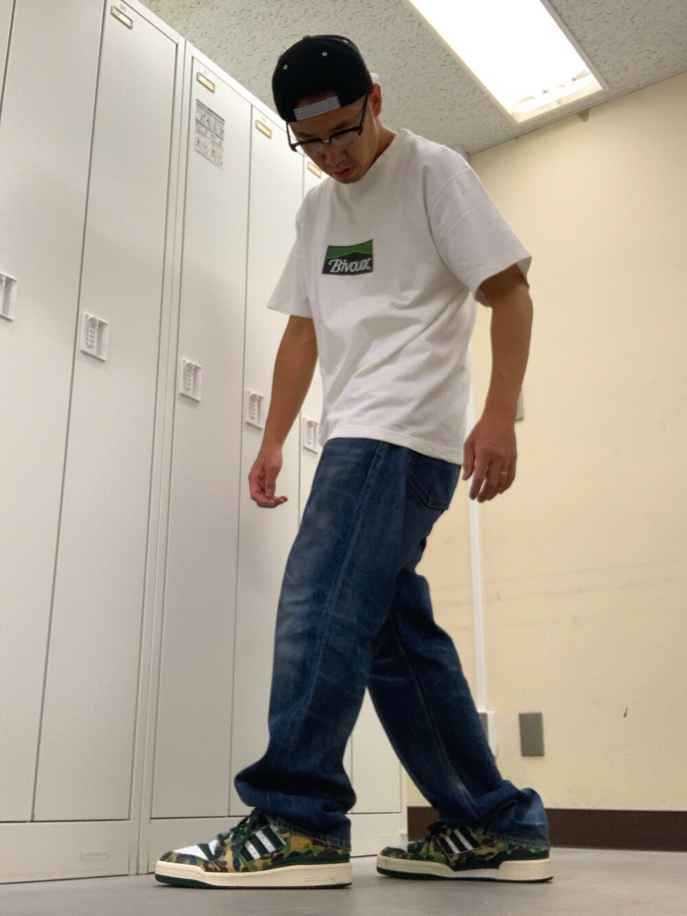 ホワイト系のTシャツ/カットソー、ブルー系のデニムパンツ、グリーン系のスニーカーを着用したメンズの秋コーディネートの2枚目の写真