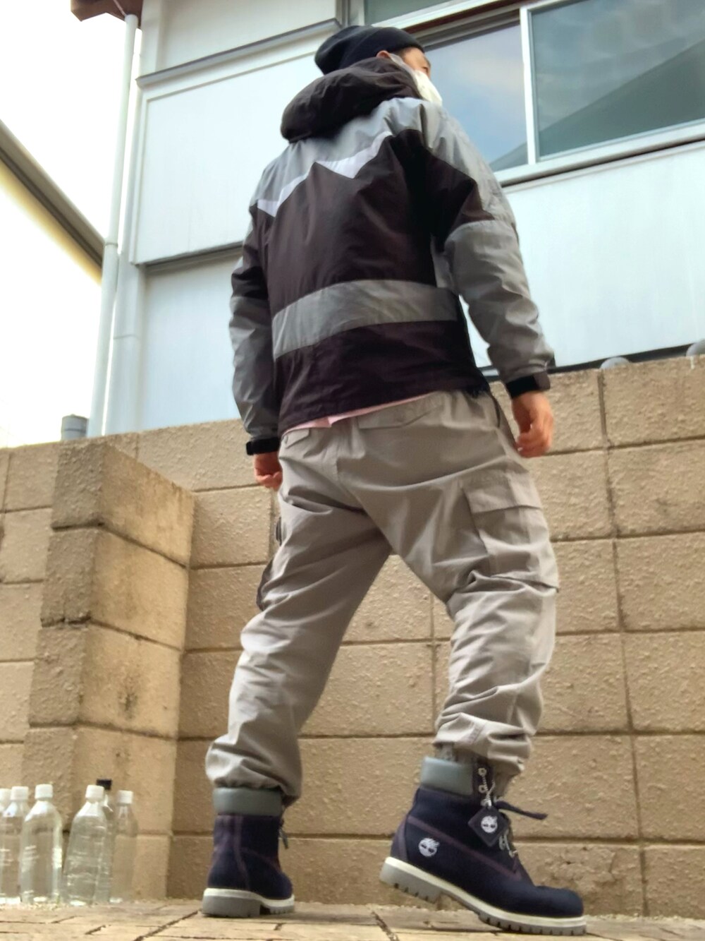 グレー系のマウンテンパーカー、グレー系のカーゴパンツ、ブルー系のブーツを着用したメンズの冬コーディネートの3枚目の写真