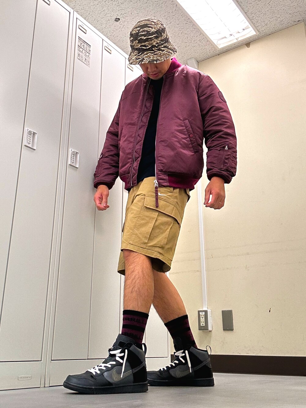 レッド系のジャケット/アウター、ベージュ系のカーゴパンツ、ブラック系のスニーカーを着用したメンズの秋コーディネートの2枚目の写真