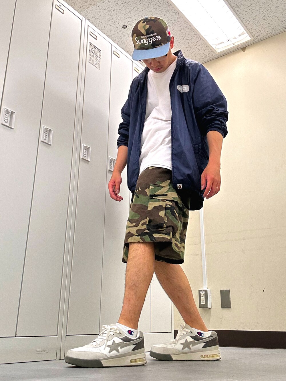 ホワイト系のTシャツ/カットソー、ブルー系のナイロンジャケット、グリーン系のカーゴパンツを着用したメンズの夏コーディネートの2枚目の写真