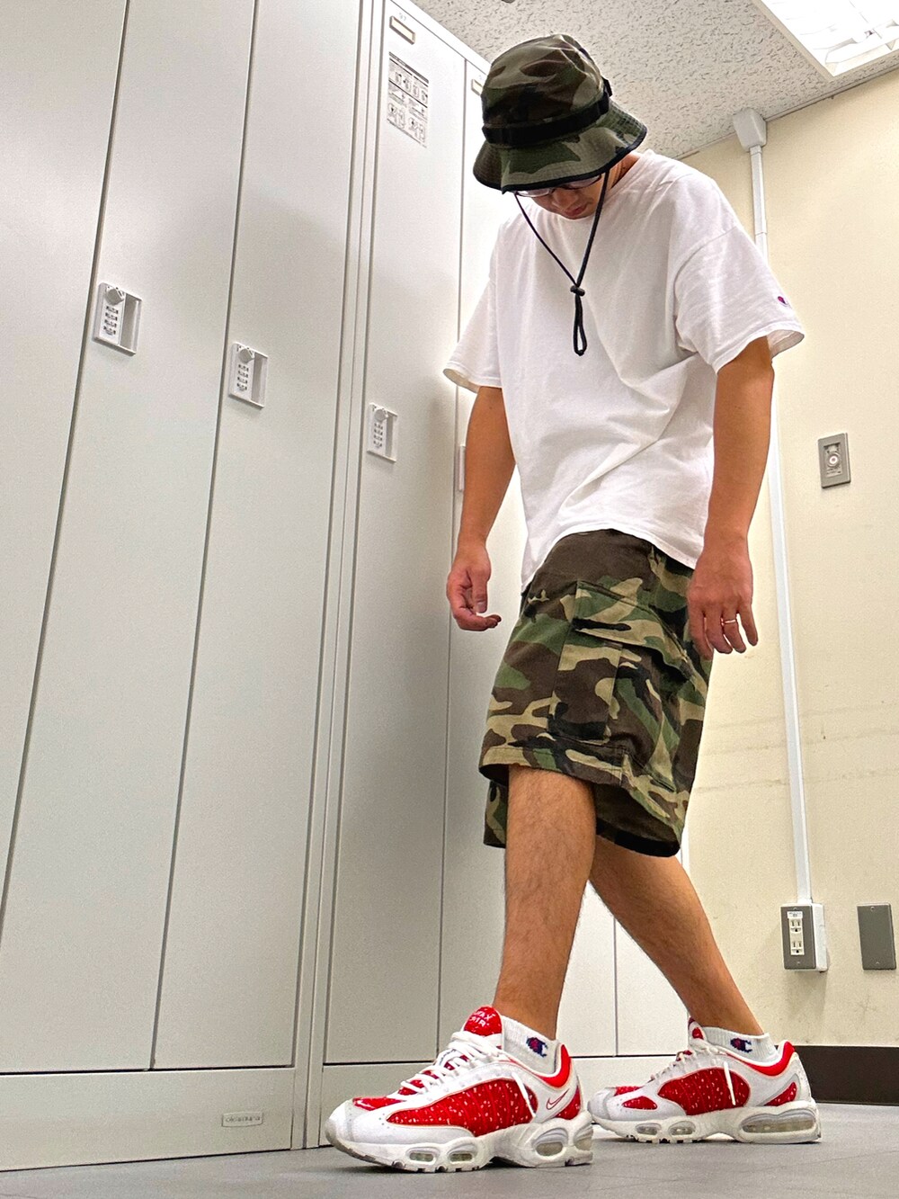ホワイト系のTシャツ/カットソー、グリーン系のカーゴパンツ、レッド系のスニーカーを着用したメンズの夏コーディネートの2枚目の写真