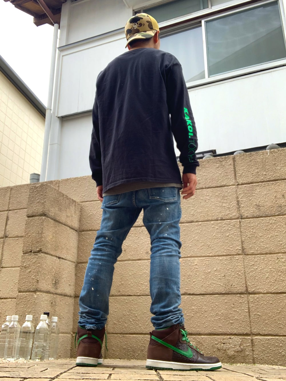 ブラック系のTシャツ/カットソー、ブルー系のデニムパンツ、ブラウン系のスニーカーを着用したメンズの夏コーディネートの3枚目の写真