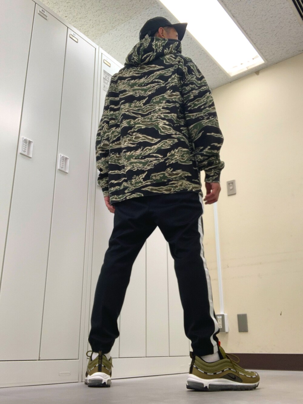 グリーン系のパーカー、ブラック系のその他パンツ、グリーン系のスニーカーを着用したメンズの秋コーディネートの3枚目の写真