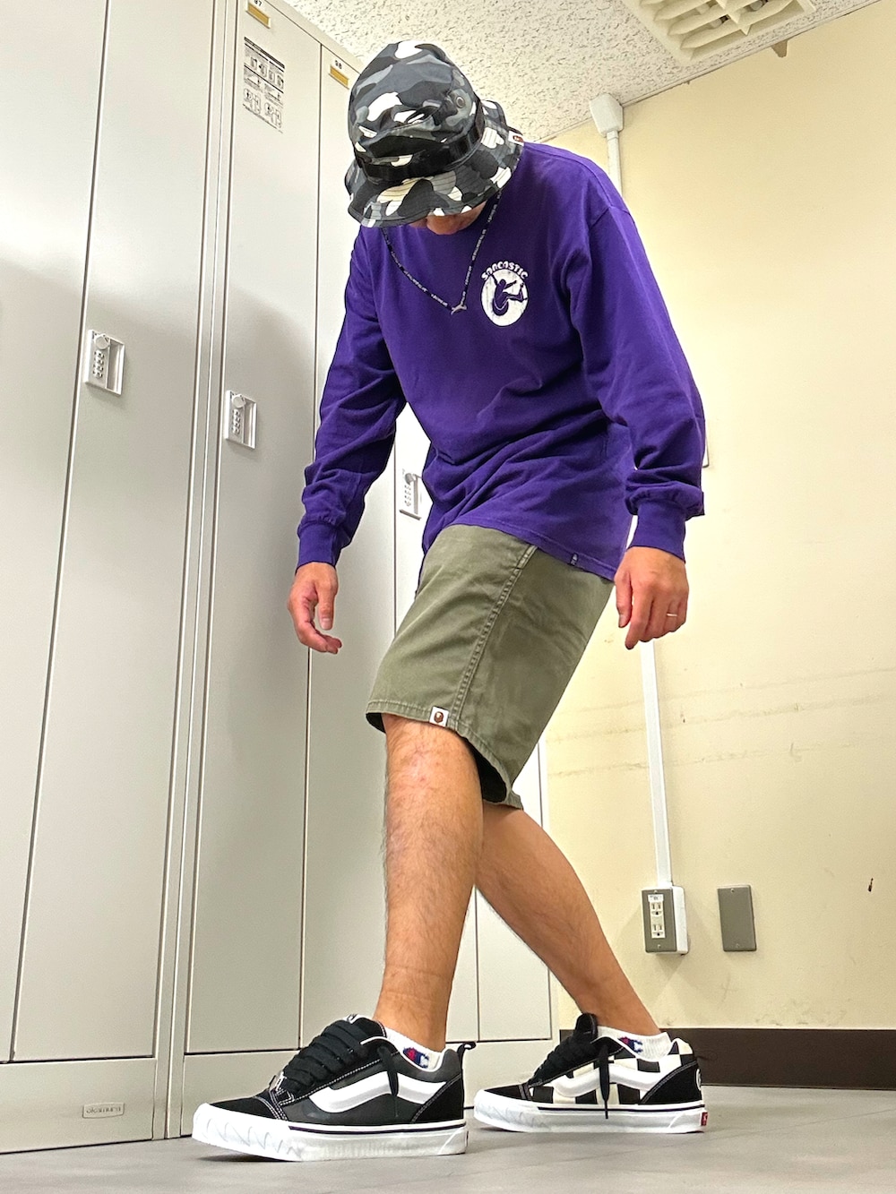 パープル系のTシャツ/カットソー、グリーン系のチノパンツ、ブラック系のスニーカーを着用したメンズの秋コーディネートの2枚目の写真