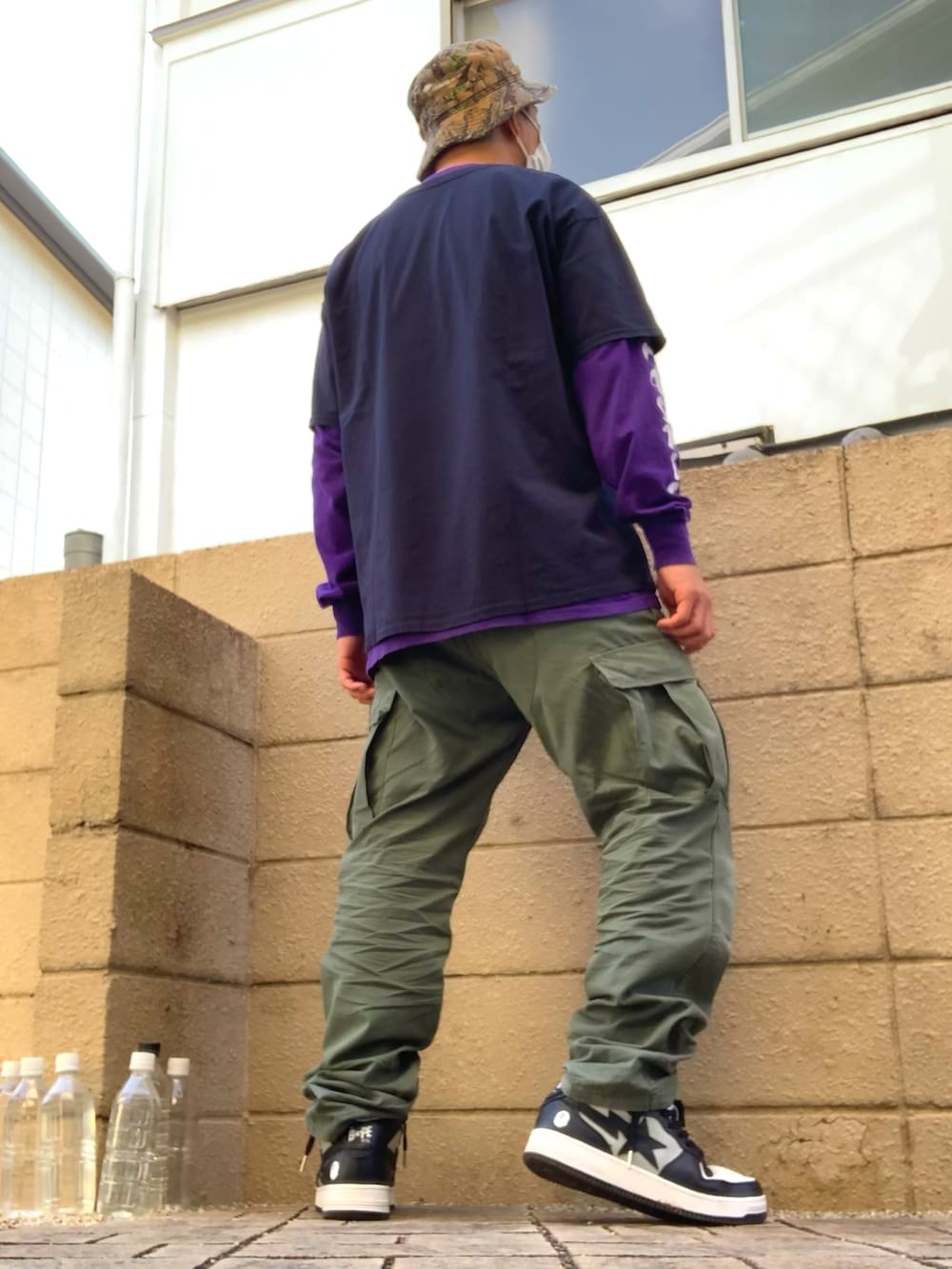 ブルー系のTシャツ/カットソー、パープル系のTシャツ/カットソー、グリーン系のカーゴパンツを着用したメンズの秋コーディネートの2枚目の写真