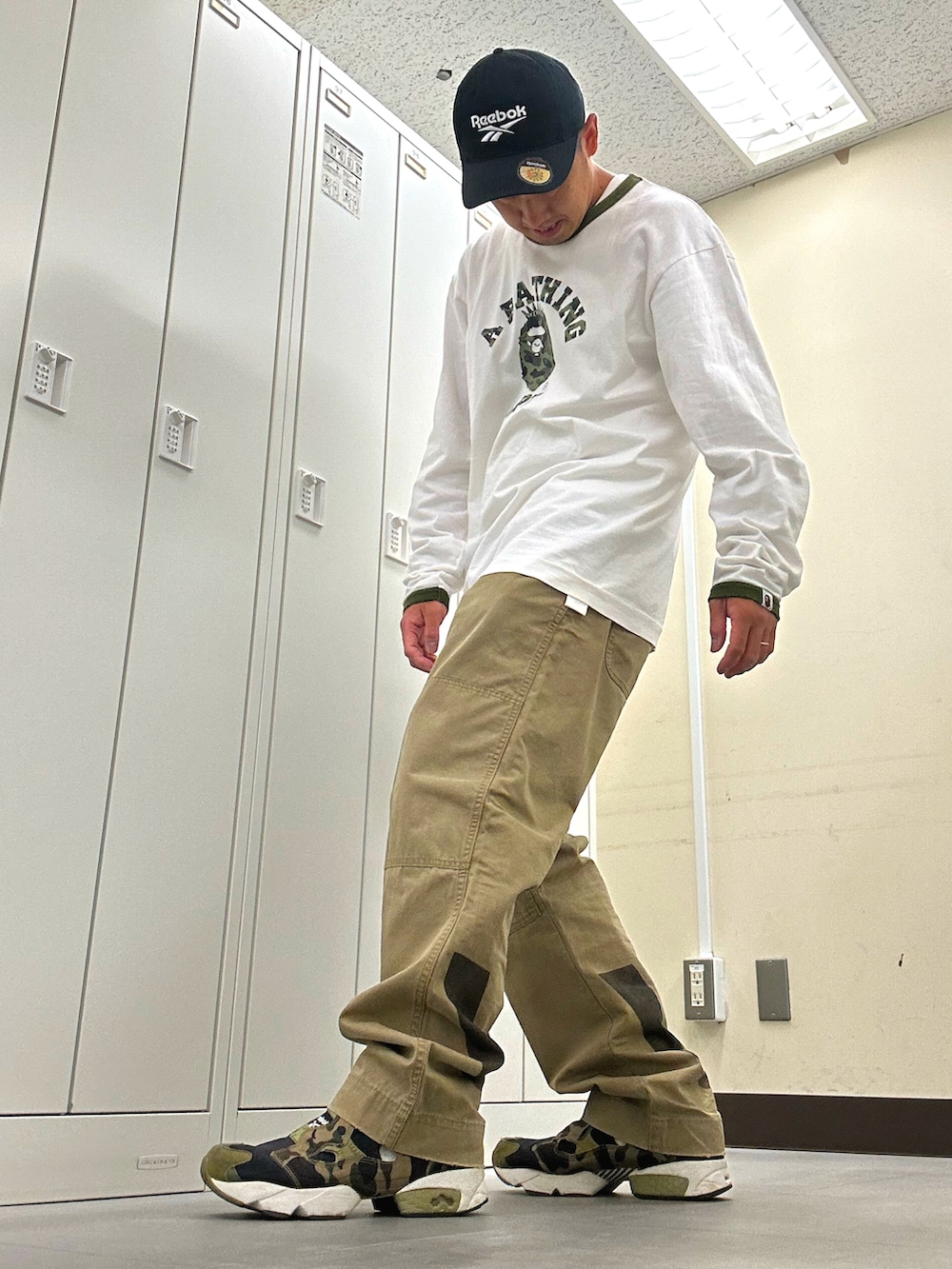 ホワイト系のTシャツ/カットソー、ベージュ系のチノパンツ、グリーン系のスニーカーを着用したメンズの秋コーディネートの2枚目の写真