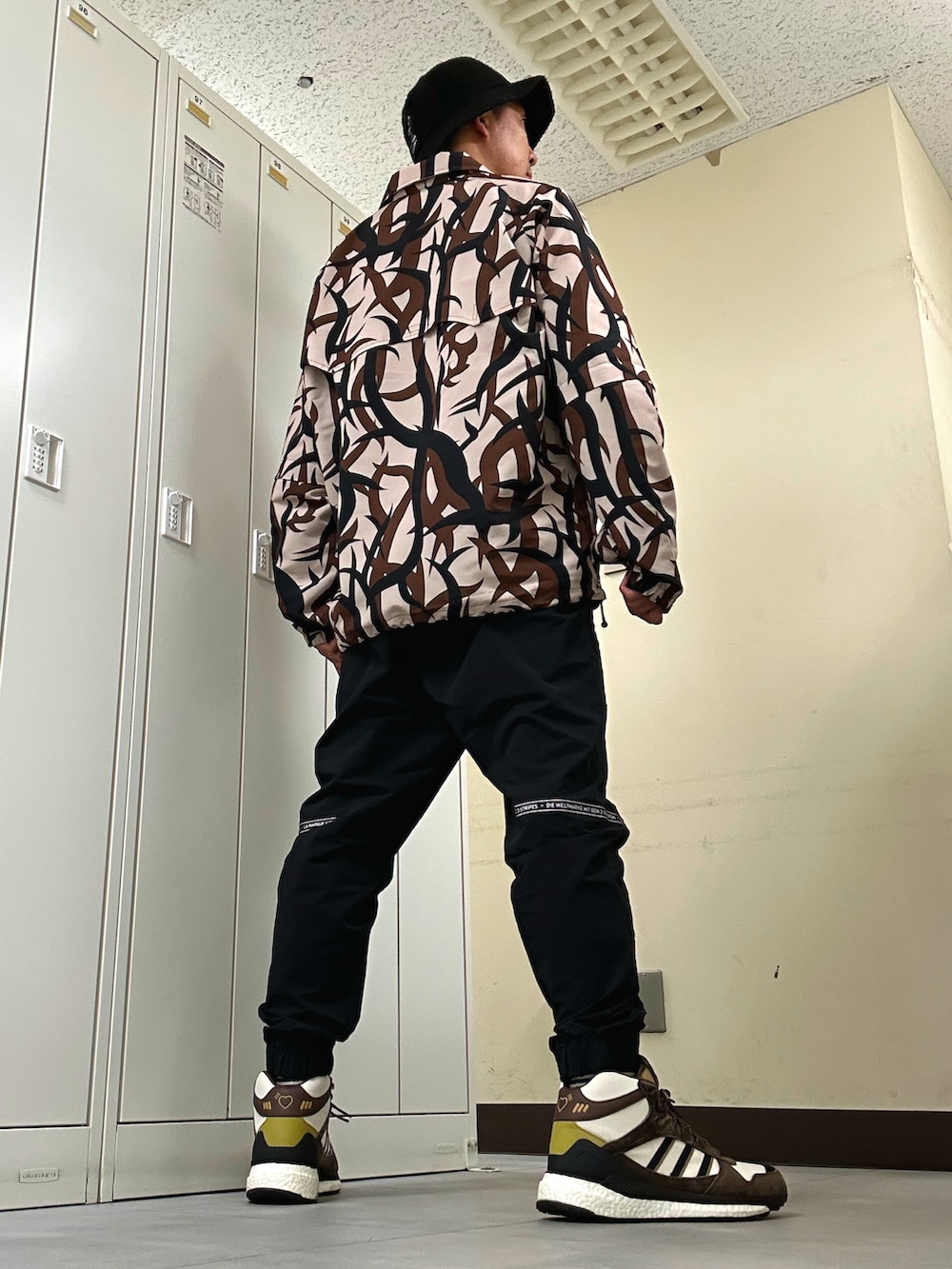 ベージュ系のナイロンジャケット、ブラック系のその他パンツ、ベージュ系のスニーカーを着用したメンズの秋コーディネートの3枚目の写真