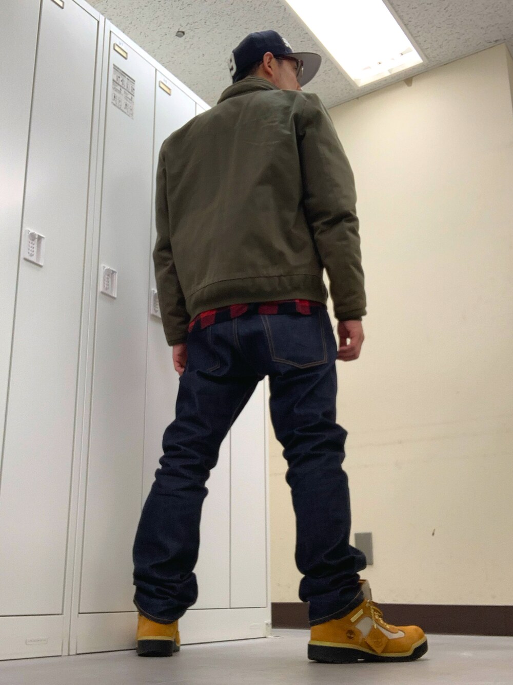 レッド系のシャツ/ブラウス、グリーン系のミリタリージャケット、ブルー系のデニムパンツを着用したメンズの冬コーディネートの3枚目の写真